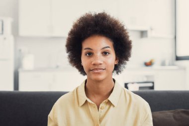 Binlerce yıllık mutlu siyah ırk portresi. Evdeki kanepede kameraya bakan ciddi bir kız. Güzel bir Afro-Amerikan genç kadın, evin içinde kadın model. Kafasından vur.