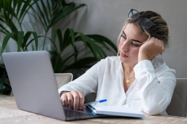 Sıkılmış Kafkasyalı genç lise öğrencisi ev ödevi okumaktan sıkılmış, sarışın genç kız sınav sınavına hazırlanıyor, edebiyat araştırması, çalışanların çalışma konsepti