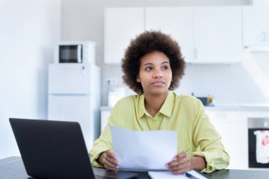 Stresli genç siyahi kadın ağır düşüncelere dalmış. Borç batağıyla ilgili kağıt döküman tutuyor. Para sorununu çözmeyi düşün. Mektupla gelen kötü haberlerle ilgili endişeli ırk kadını.