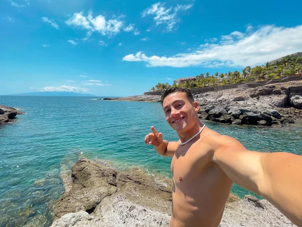 Jeden Atraktivní Šťastný Mladý Muž Pláži Usmívá Dívá Kamery Drží — Stock fotografie