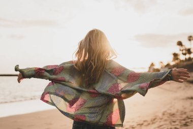 Mutlu, güzel bir kadın kumsalda yürüyor ve gün batımında eğleniyor. Tatillerde boş zaman, özgürlük kavramı