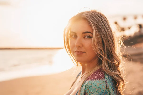 stock image Portrait of young beautiful woman on beach enjoying and relaxing sunset. Looking at the camera serious 