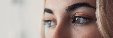 Mavi gözler genç, güzel, sarışın, sağlıklı, pürüzsüz tenli bir kadının gözlerini kapatıyor. Yan görüş, kırpılmış atış. Kadın modeli güzellik ve kozmetolojiyi destekliyor..