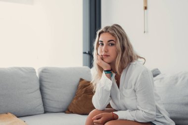 Milenyum modelinden olumlu bir kız. Kadın portresi. Güzel, genç, beyaz bir kadın kameraya bakıyor, dairede poz veriyor. Ön profil resmi