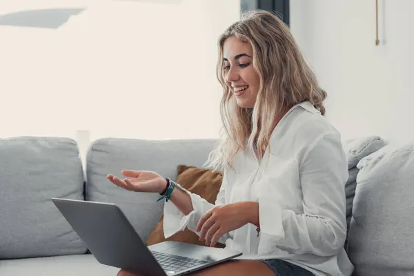 Portrait of young beautiful blonde girl talking with colleagues studying online in class room videocall learning. Working woman in a video conference.