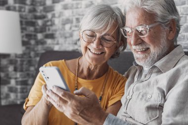 Yaşlı büyükbaba ve büyükanne akıllı telefon uygulamaları, orta yaşlı eş çevrimiçi eğlencelerden, eski koca, eski nesil ve modern teknoloji konseptiyle selfie çekmekten zevk alarak zaman geçiriyorlar.