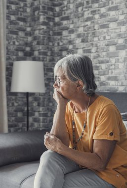 Face of senior caucasian hoary woman looking away deep in sad thoughts feels lonely close up portrait, recollect memories and life moments, depressed grandmother alone indoors, yearning for husband concept