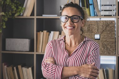 Genç ve mutlu bir kadının, kameraya bakıp eğlenen portresi. Ofiste çalışan bir kadının vesikalığı..