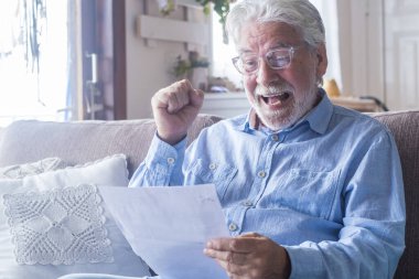 Heyecanlı yaşlı adam sağlık sigortası anlaşmasının kapanışını kutluyor ve tıbbi sonuçları okuyor. Mutlu son sınıf öğrencisi çok mutlu. Uzman doktorla iyi bir anlaşma imzala. Evde sonuçlar kontrol ediliyor.