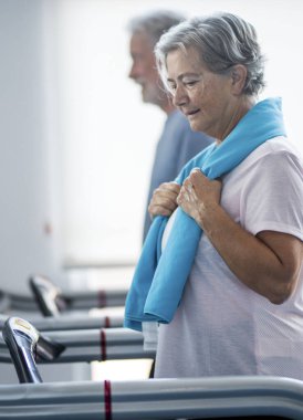 Spor salonunda birlikte antrenman yapan iki son sınıf öğrencisi ve yetişkin insan - sağlıklı ve sağlıklı yaşam tarzı kavramı - Tapirulan 'da yürüyorlar.