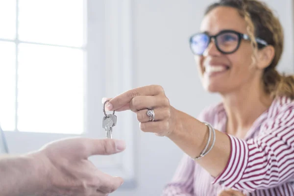 Crop close up of realtor give keys to man buyer or renter buying first home from agency. Real estate agent or broker congratulate male tenant with house or flat purchase. Ownership, rental concept.