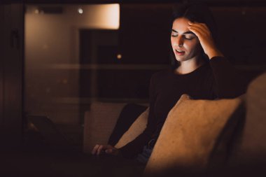 Gece yarısı stresli bir kadın bilgisayar çalışmasından sonra şiddetli bir baş ağrısı nöbeti geçiriyor. Kronik migren ağrısı çeken uykulu, yorgun bir kız baş ağrısını azaltmak için şakaklara masaj yapıyor.