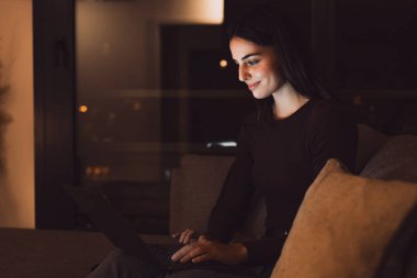 Mutlu, genç bir kadının gülümsemesini ve evinde dizüstü bilgisayar kullanmasını kanepeye oturup tek başına ders çalışmasını. Milenyum kızı açık havada yüzüyle kanepede dinlenerek sörf yapıyor..