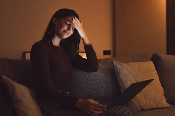 stock image Stressed woman at late night having strong terrible headache attack after computer laptop study, sleepy exhausted girl suffering from chronic migraine massaging temples to relieve head ache tension