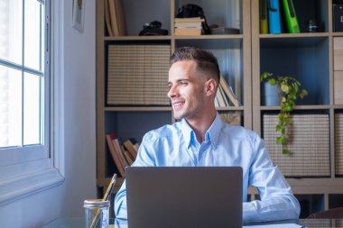 Kafkas refleksi laptopa bakıyor, işte refleks gösteriyor, zor bir projede iş adamı bağımsız çalışıyor. Ofiste evde hazırlanan bir erkek..