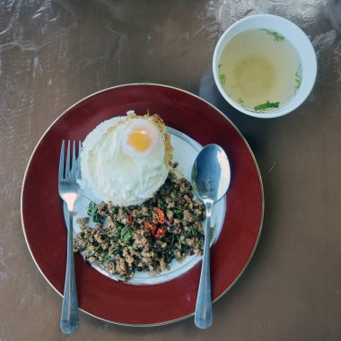 Fesleğenli kıymalı domuz eti ve pilavlı sahanda yumurta.