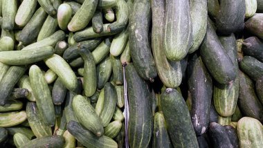 Piyasada sergilenen taze salatalıklar, çeşitli boyutlarda ve yeşil tonlarda, sağlıklı beslenmeye davetiye çıkarıyor.