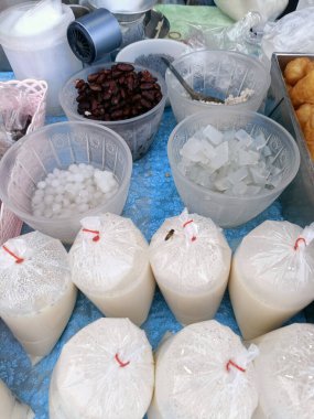 Masadaki plastik kapta çeşitli tatlı malzemeler sergileniyor, davetkar bir sahne yaratıyor ve lezzetli bir ikram hissi uyandırıyor.