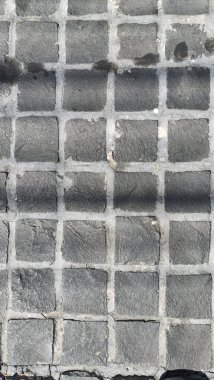 Yıpranmış taş kaldırımlara yakından bakın. Düz olmayan, çatlamış ve yontulmuş taşlar. Yaşlanma ve yıpranma belirtileri gösteriyor.