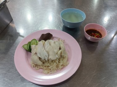 Haşlanmış tavuklu pilav ve mis kokulu pilav. Salatalık, baharatlı sos ve taze et suyu ile servis edilir. Lezzetli sokak yemeği.