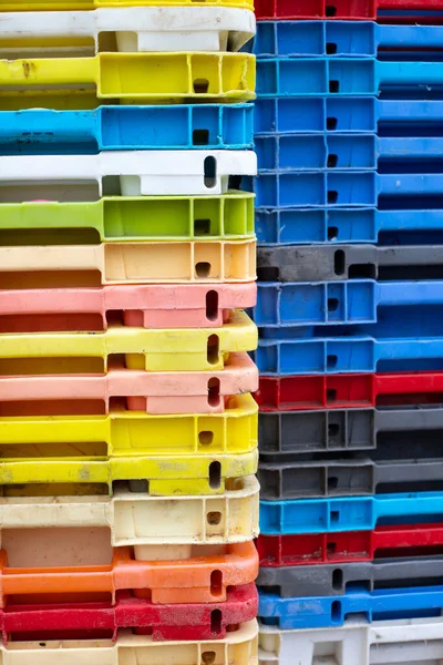 Arka plan, doku ya da kaplama olarak kullanılabilecek çok renkli plastik balıkçı sandıkları yığınını kapat