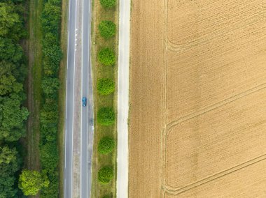 Buğday tarlasının ortasındaki bir yolun havadan görünüşü. Geometrik şekiller, arkaplan olarak kullanılabilen resim