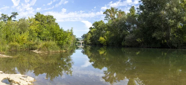 Fransa 'nın güneyinde La Roque sur Cze yakınlarında eski bir ortaçağ köprüsü ve nehrin panoramik görüntüsü
