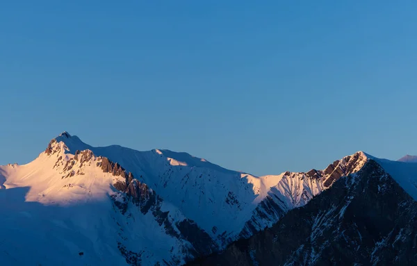 Batan Güneşin Aydınlattığı Karlı Tepelerin Muhteşem Panoramik Manzarası — Stok fotoğraf