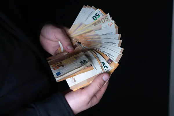 Ödeme yapmak için 50 Euro 'luk banknotları tutan el kameraları.