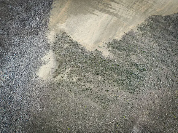 Aerial view with a drone showing a sandy and pebble beach, textured image that can be used as a background