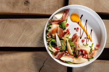 Camembert ve jamonlu salata, roka ve hafif seramik tabakta balzamik ve hardal soslu fındık..