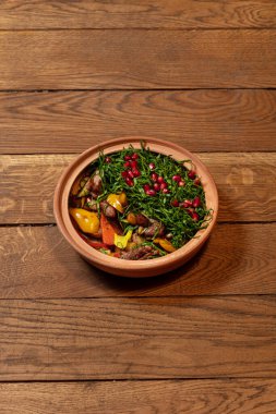 Patatesli kuzu fileto, pırasa, doğranmış kişniş yastığının altında nar tohumlu paprika. Yemekler seramik yuvarlak şekilli..