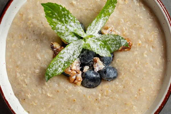 Breakfast Oatmeal Milk Blueberries Hazelnuts Mint Leaves Powdered Sugar Plate — Stock Photo, Image