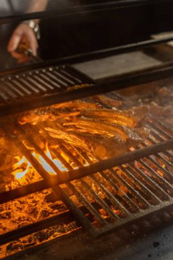 Bir kaç parça kuzu pirzola kızgın kömürlerin üzerinde metal ızgarada yatıyor..