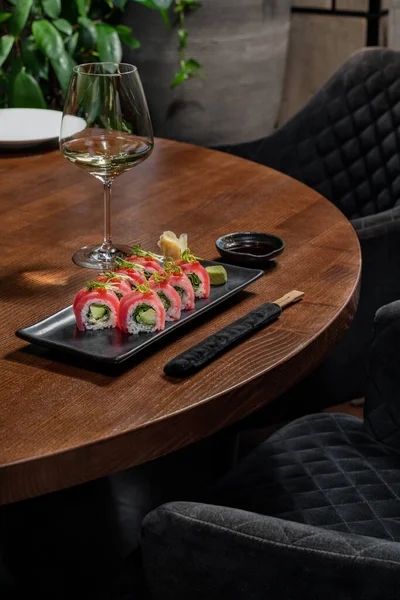 Sushi Rolka Avokádem Zabalená Tuňákovi Zelenými Cibulovými Lupínky Leží Keramickém — Stock fotografie