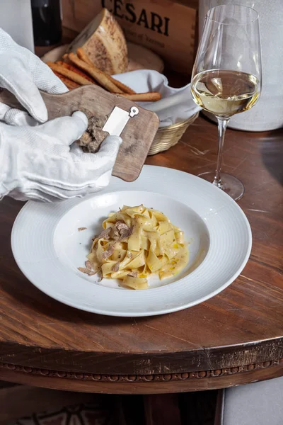 ワインのグラス バスケットのグリッシーニと木のテーブルにトリュフとプレートでソースのスパゲッティ — ストック写真
