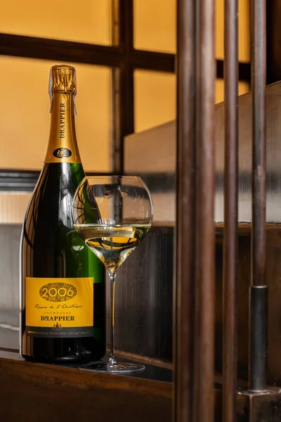 一瓶Grande Sendre 2006 Magnum香槟 旁边倒了一杯香槟 瓶子和玻璃杯架在金属台阶上 — 图库照片
