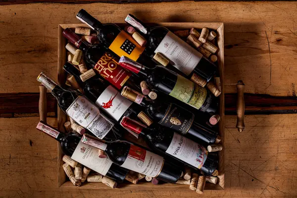 Masada şarap mantarları olan bir kutuda farklı şarap şişeleri vardı.