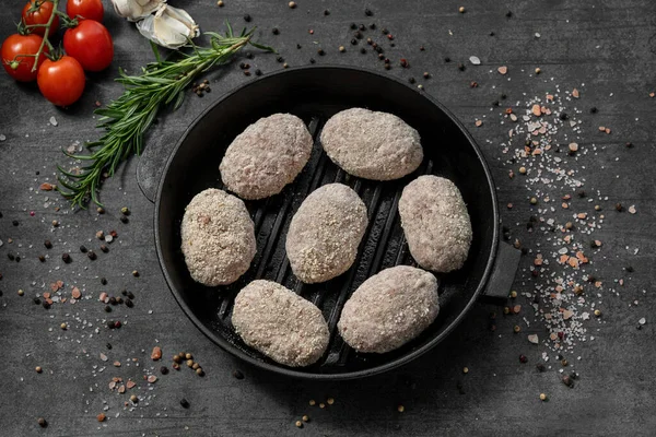 トルコの小麦粉のパンフレット 黒い鋳鉄パンに横たわっている 暗い石の背景に立っている料理 スパイスとハーブが散らばっています — ストック写真