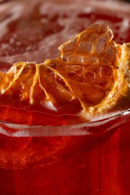 Aperol ve burbonlu kokteyl, vermut ve şeker şuruplu limon suyu. Eski moda bir bardakta bir kokteyl, tuğla bir yüzeyde duruyor..