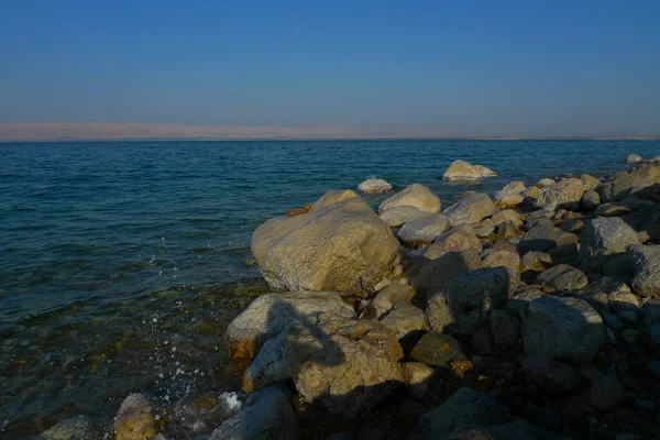 Kuru tuza bulanmış taşlarla kaplı güzel ölü deniz kıyıları.