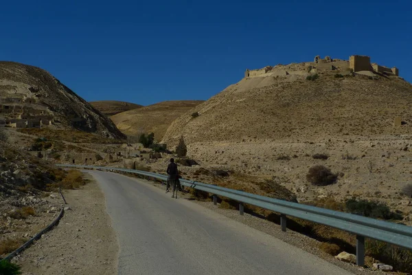 Haçlının şatosuyla yol manzarası tepenin üstünde harabe.
