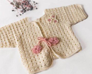 Tığ işi bebek ürünü. Beyaz arkaplanda giysi ve aksesuarlar.