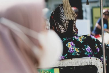 Jalan Malioboro, Yogyakarta 'da bir araba ya da Andong sürücüsü var. Tipik Cava batik kıyafetleri ve beyaz şapkalarıyla..