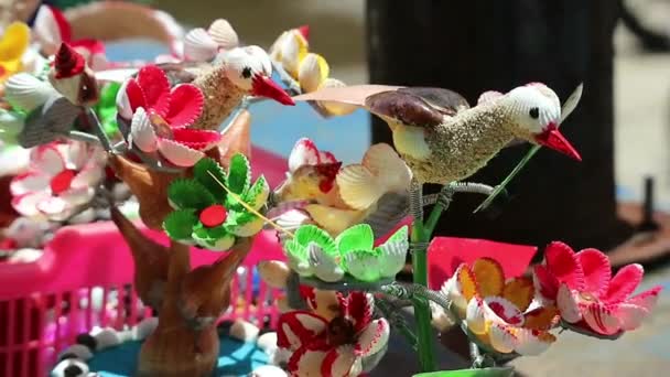 色鮮やかな貝殻で作られたビーチのお土産 クラフトミニチュア鳥や花 とてもきれいで美しい 風に乗って移動する ジョグジャカルタのグヌンキドゥルのバロンビーチで — ストック動画