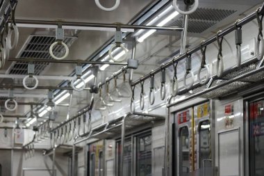 Trenin hareketi nedeniyle sallanan yolcuların el kolu ya da el ele tutuşları ya da tırabzanları. Tren boş, yolcu yok..