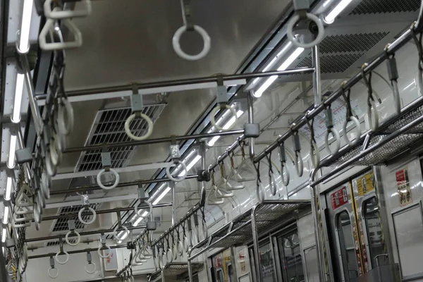 The hand handle or handgrips or handrails of commuter line passengers swaying due to the movement of the train. The train is empty with no passengers.