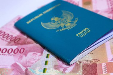 Arkaplanı 100.000 rupia olan Endonezya yeşil pasaportu. Bu pasaport yurtdışına giden Endonezya vatandaşları için bir kimlik. Endonezya parası rupiadır..