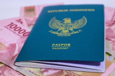 Arkaplanı 100.000 rupia olan Endonezya yeşil pasaportu. Bu pasaport yurtdışına giden Endonezya vatandaşları için bir kimlik. Endonezya parası rupiadır..