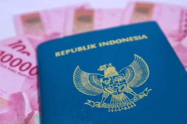 Arkaplanı 100.000 rupia olan Endonezya yeşil pasaportu. Bu pasaport yurtdışına giden Endonezya vatandaşları için bir kimlik. Endonezya parası rupiadır..